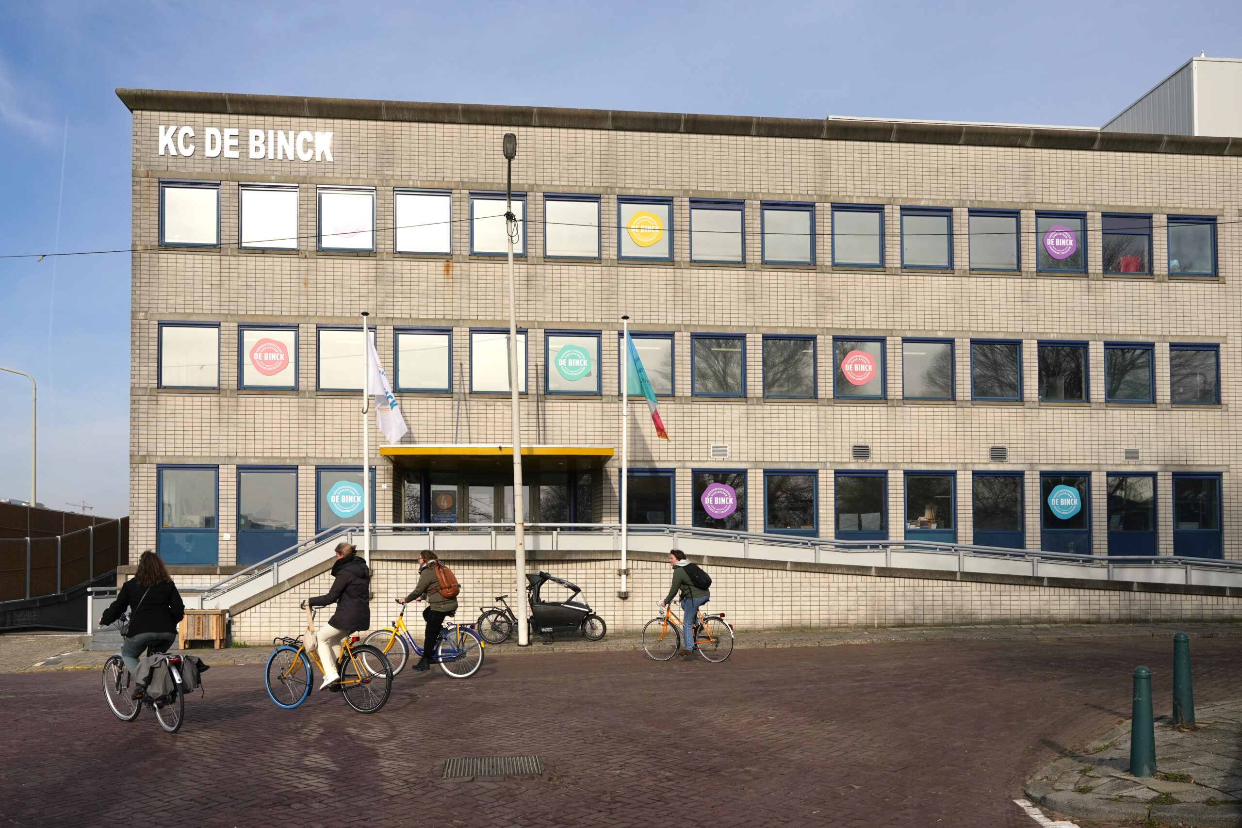 Het gebouw van kindcentrum De Binck, met op de voorgrond fietsers.