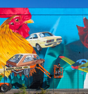 Graffiti met afbeeldingen van auto's, hoogwerker, groen en hanen.